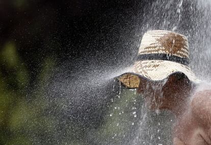 Un hombre toma una ducha fría para refrescarse en el lago Ada Ciganlija en Belgrado, Serbia, donde las temperaturas han alcanzado los 35 C.