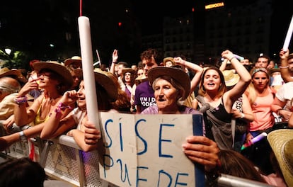 Una seguidora de Unidos Podemos sostiene un cartel con el lema 'Sí se puede' y una vela en la plaza Reina Sofía de Madrid.