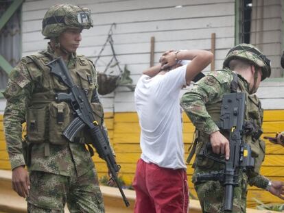 Military police search two young men.