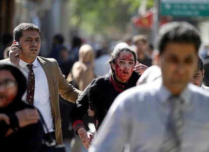 Una mujer afgana huye del lugar de la explosión en Kabul.