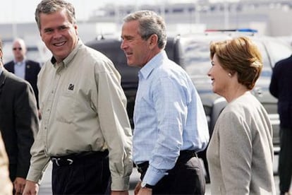 El gobernador de Florida, Jeb Bush (izquierda); su hermano, el presidente Bush, y su esposa, Laura, ayer en Florida.