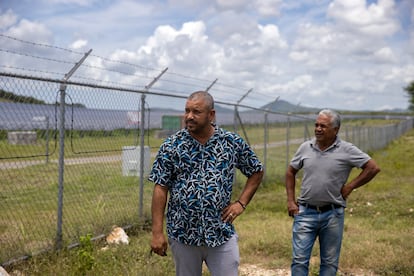 Carlos Suazo y Euclides Lluberes conversan cerca de la verja que rodea la planta solar Girasol.