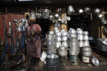 Una mujer vende menaje y utensilios creados a partir de metal reciclado de barriles de petróleo. La escena es de un mercado de Kamukunji, Nairobi, y fue tomada el 16 de febrero.