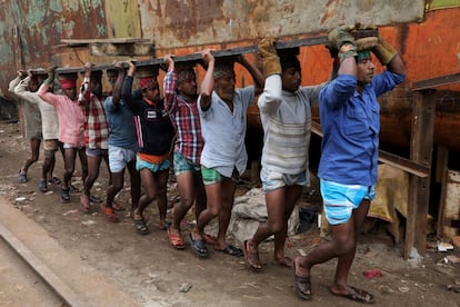 Trabajadores de Bangladés transportan una pieza de metal en Daca (Bangladés).