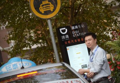 Un conductor de taxi espera a sus clientes en una estación de Didi en Shanghái.