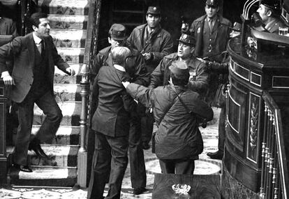 Adolfo Suárez, depois de levantar de sua cadeira, enfrenta a polícia civil que rodeia o general Manuel Gutiérrez Mellado durante o golpe ao Congresso de dos Deputados do dia 23 de fevereiro de 1981.