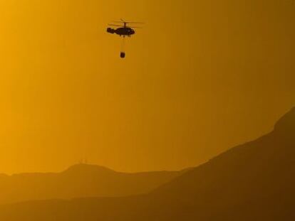 Un helicóptero se dirige este viernes a cargar agua para combatir el incendio de Canillas de Aceituno.