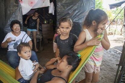 Paloma, nicaragüense de 17 años, en primer plano rodeada de sus hermanas y de Milagros, trabajadora social.