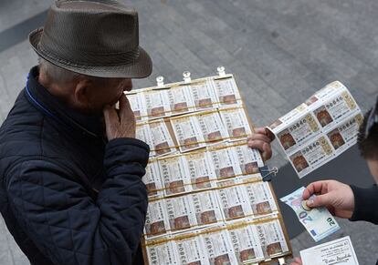 Un hombre compra billetes de la Lotería de Navidad en Madrid.