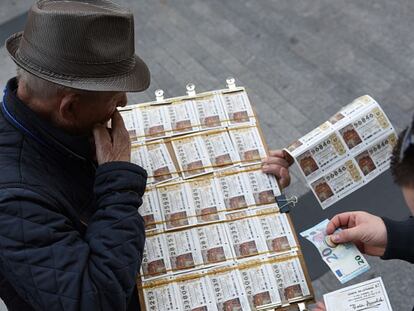 Un hombre compra billetes de la Lotería de Navidad en Madrid.