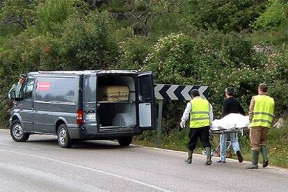 Trabajadores de los servicios funerarios introducen en un vehículo el cuerpo de la mujer hallada hoy muerta con Pego.