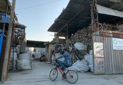 Un niño en bicicleta se detiene frente a una planta de reciclaje de plástico en Adana, Turquía.