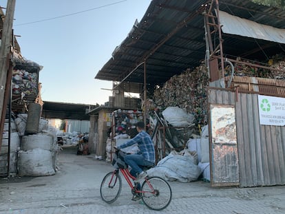Un niño en bicicleta se detiene frente a una planta de reciclaje de plástico en Adana, Turquía.