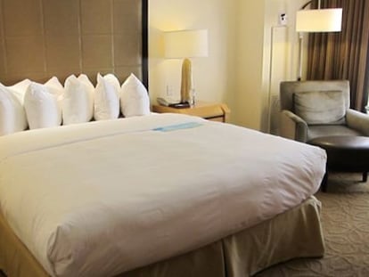 Una cama con almohadas en uno de los hoteles de Conrad.