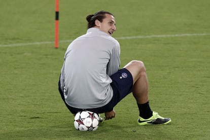 El jugador sueco del Paris Saint Germain Zlatan Ibrahimovic se ata las zapatillas durante un entrenamiento. El conjunto francés se mide al Olympiacos en Grecia.