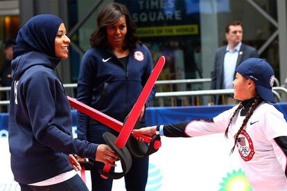 Ibtihaj Muhammad juega con una niña ante la mirada de Michelle Obama.