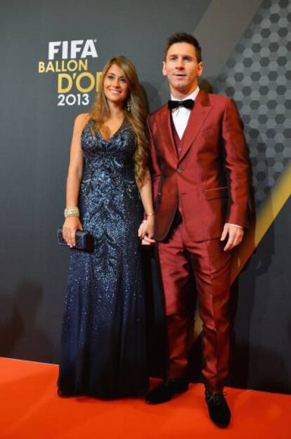 Messi, con un arriesgado traje rojo brillante, junto a su mujer Antonella antes de la entrega del Balón de Oro 2013.