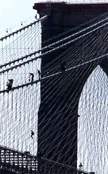La policía intenta alcanzar al hombre que se subió a los cables del puente de Brooklyn. En la foto puede vérsele abajo a la izquierda.