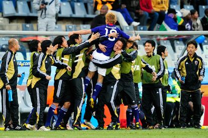 Keisuke Honda celebra, también saltando sobre sus compañeros, el gol marcado a Camerún.