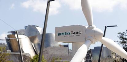 Imagen de un aerogenerador de Siemens Gamesa en Bilbao, con el museo Guggenheim al fondo.