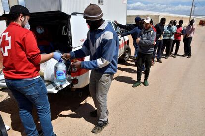 Personal de Cruz Roja reparte alimentos, útiles de limpieza y material escolar a los inmigrantes del asentamiento chabolista de El Cruce en la provincia almeriense de Níjar.