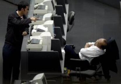 Dos agentes de bolsa indonesios conversan en el parqué de la Bolsa de Yakarta.