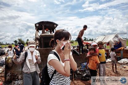 Un camión cargado de residuos llega hasta el basurero de Siem Reap (Camboya). Se estima que en este lugar trabajan unos 20 menores de edad con sus familias. Visita el basurero dentro de una ruta turística. En la imagen, una turista japonesa se tapa la boca y la nariz ante el fuerte olor que desprenden los gases del basurero de Siem Reap (Camboya).