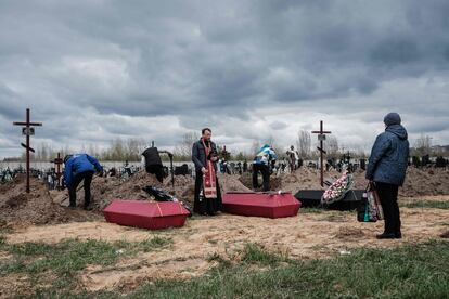 Un sacerdote oficia un funeral por varios muertos tras los ataques de las tropas rusas en la ciudad de Bucha, el 18 de abril. 