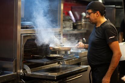 Un empleado de Pura Brasa Gastronomic Grill, en Pineda de Mar, durante un servicio de comidas. 