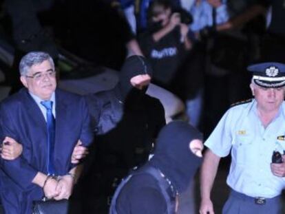 El líder de Aurora Dorada, Nikos Mijaloliakós, escoltado por la policía a su entrada a los juzgados de Evelpidon, en Atenas.