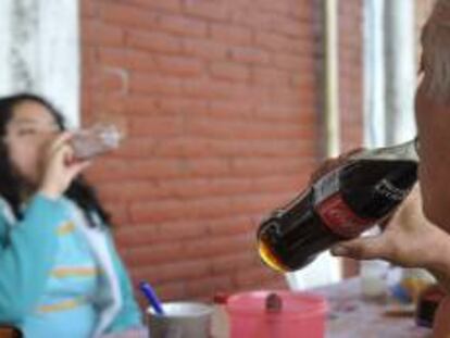 Dos personas consumen refrescos en Ciudad de México. EFE/Archivo