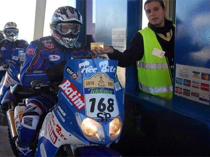 Los motociclistas, pagando el peaje en la autopista Marbella-Algeciras.