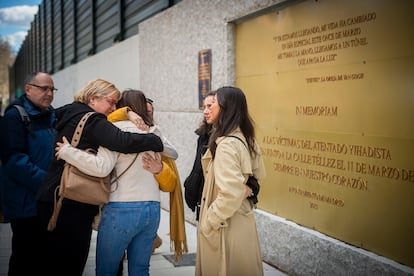 Varias personas se abrazan en la placa conmemorativa de la calle Téllez, este lunes durante el 20º aniversario de los atentados 11-M.