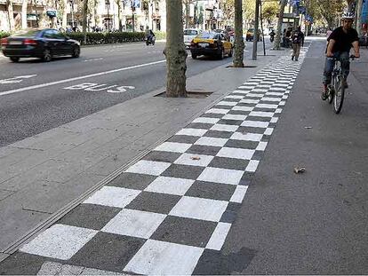 Señales horizontales en blanco y negro para indicar precaución en los carriles bici próximos a las paradas de autobuses en la Gran Via.