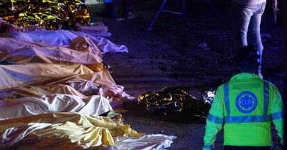 Personal de emergencias junto a los cadáveres de varias de las víctimas del accidente, en Mestre.