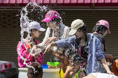 Agua arrojada con coloridas pistolas de juguete, mangueras y cubos desde camionetas, motocicletas e incluso balcones marcan la celebración de la bienvenida del Año Nuevo budista, mientras los participantes se esconden detrás de árboles y muros o dentro de restaurantes y tiendas. En la foto, mujeres salpican agua en la provincia de Prachinburi.