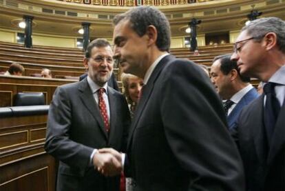 Rajoy y Zapatero se estrechan la mano en presencia de Aguirre ayer en el Congreso.