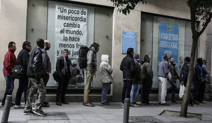 Colas de ciudadanos con problemas económicos para recoger el almuerzo ofrecido en la parroquia de San Antón.