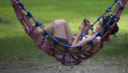 Una chica navega en Internet con su m&oacute;vil.