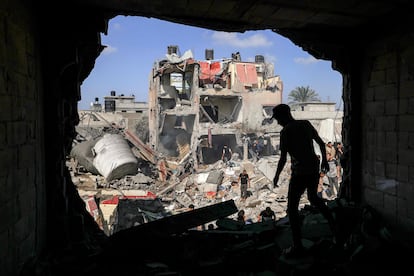 Unos jóvenes buscan supervivientes entre los escombros tras un bombardeo israelí, este miércoles en Jan Yunis.