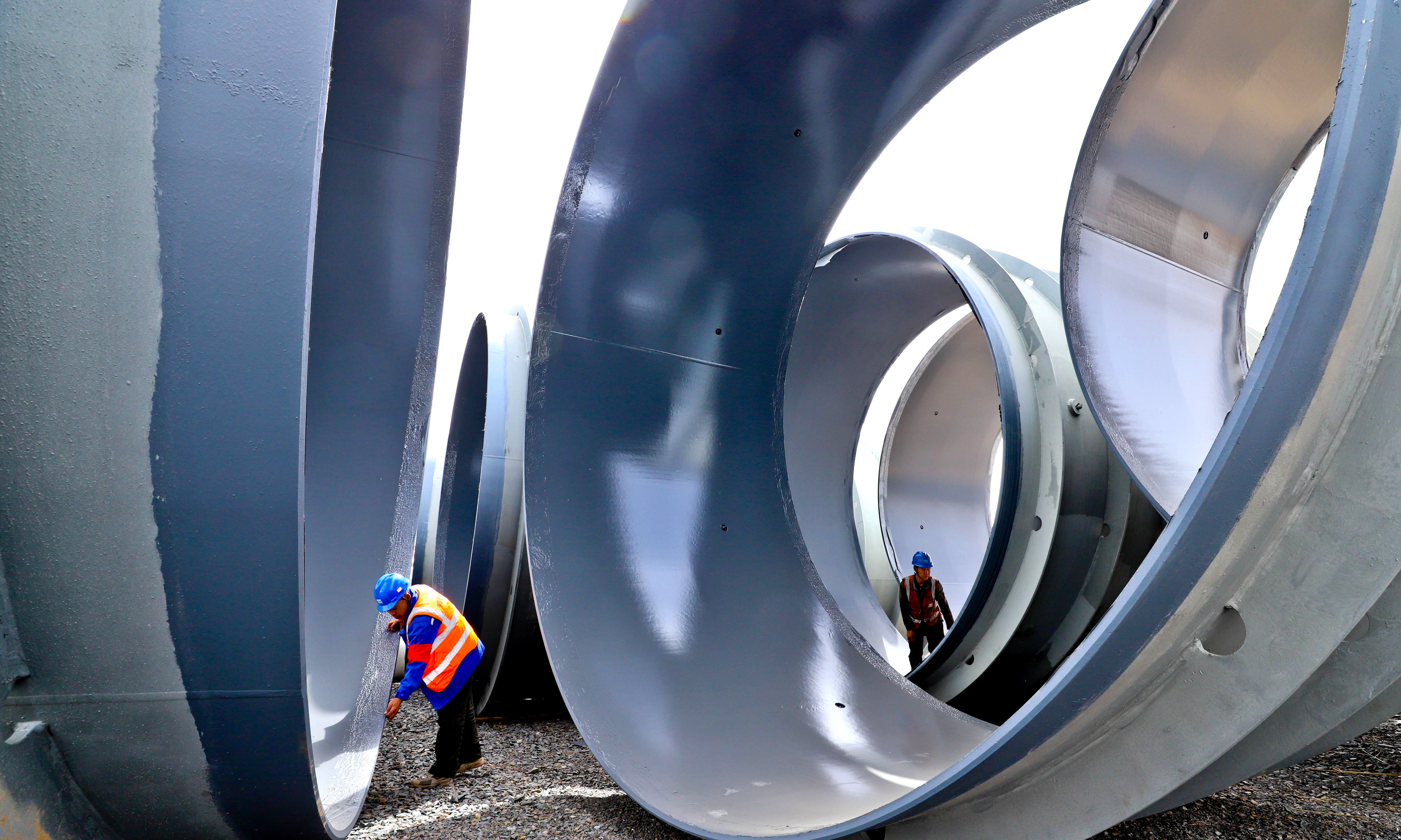 Ingenieros inspeccionan la calidad de grandes tubos de acero a presión en una planta de procesamiento en la ciudad de Zhangye, provincia de Gansu, China.