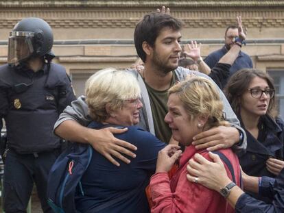Varias personas lloran en el exterior del Instituto Can Vilumara de L'Hospitalet de Llobregat ante el despliegue policial.