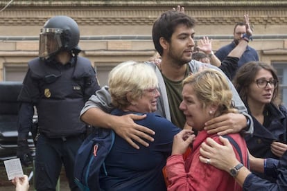 Varias personas lloran en el exterior del Instituto Can Vilumara de L'Hospitalet de Llobregat ante el despliegue policial.