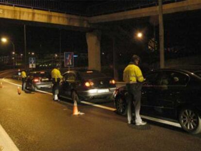 Tres guardias civiles de Tráfico realizan un control de alcoholemia en el kilómetro 45 de la M-40, a la altura de Pozuelo de Alarcón.