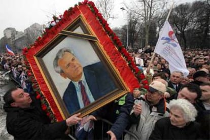 Seguidores de Milosevic sostienen un retrato del ex presidente serbio durante la marcha de ayer en Belgrado.