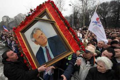 Seguidores de Milosevic sostienen un retrato del ex presidente serbio durante la marcha de ayer en Belgrado.