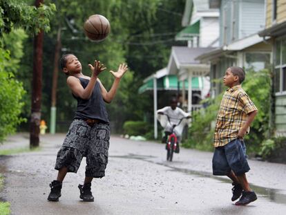 Dos ni&ntilde;os juegan a baloncesto en una calle de Akron, estado de Ohio.