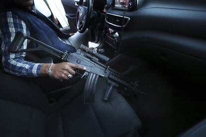 Un guardaespaldas asignado por el Gobierno para Guillermo Valencia sostiene su arma durante una parada de campaña.