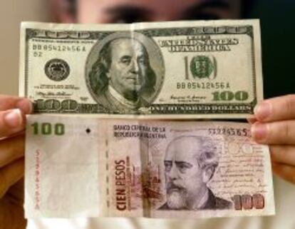Un billete de 100 d&oacute;lares y otro de 100 pesos argentinos.