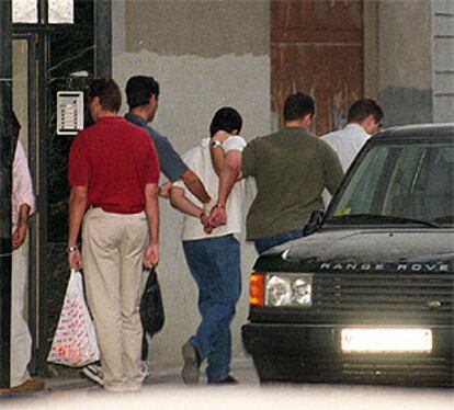 La policía se lleva esposado a un delincuente tras un tiroteo en Ciudad Lineal el pasado agosto.